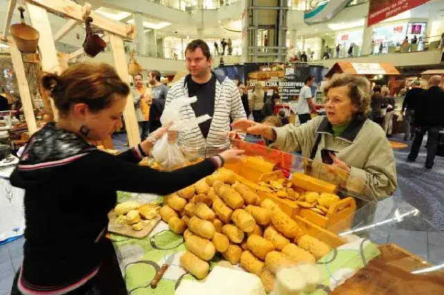 Turysta kupujący oscypki od bacy, tradycyjny strój góralski